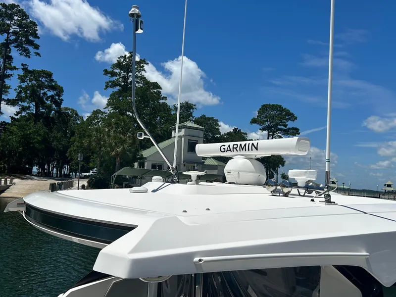 Slide: The Image of 2023 Tiara Yachts 43 LE with Garmin radar, docked near trees and blue sky. - 8