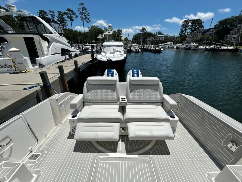Slide: The Image of 2023 Tiara Yachts 43 LE luxury boat with plush seating at a marina dock. - 9