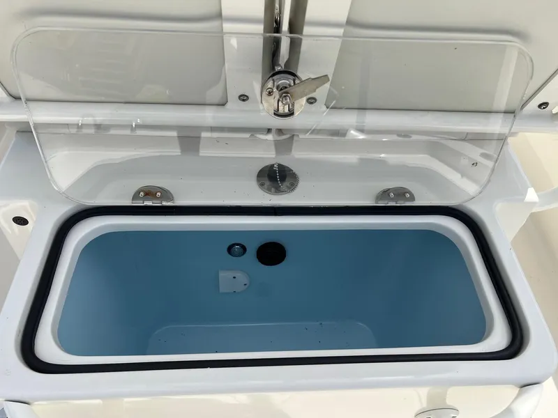 Slide: The Image of Open livewell on 2015 Ranger 2510 Bay boat, featuring a blue interior and transparent lid. - 10