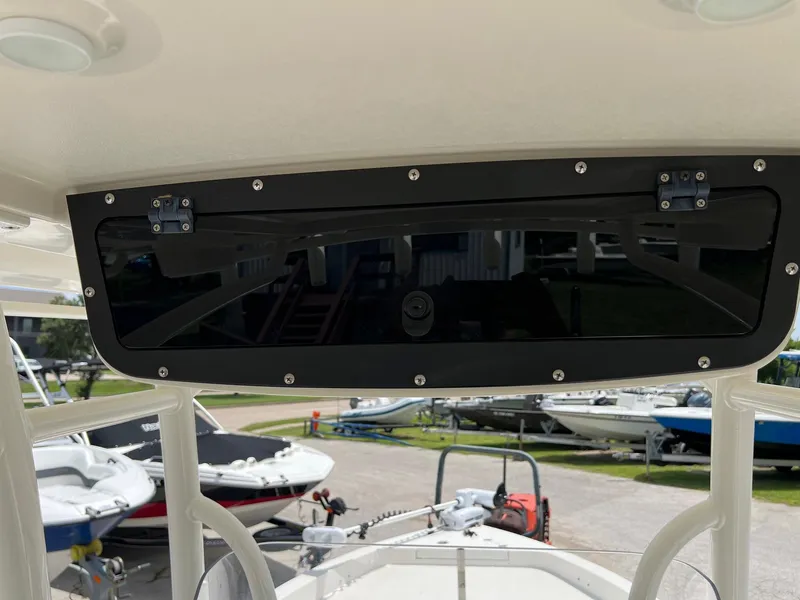 Slide: The Image of 2015 Ranger 2510 Bay boat console with storage compartment, surrounded by parked boats. - 17