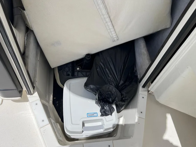 Slide: The Image of Storage compartment in a 2015 Ranger 2510 Bay boat with cooler and black bag. - 22