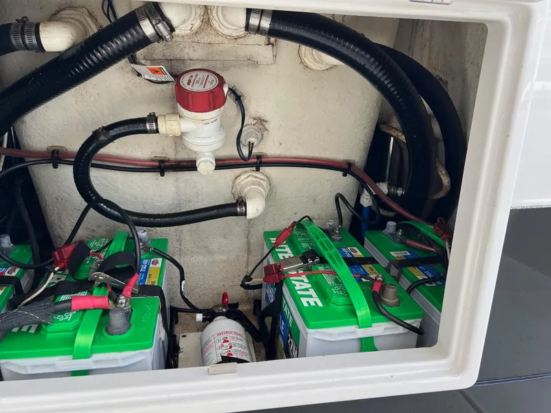 Slide: The Image of 2015 Ranger 2510 Bay boat battery compartment with wiring and connections. - 24