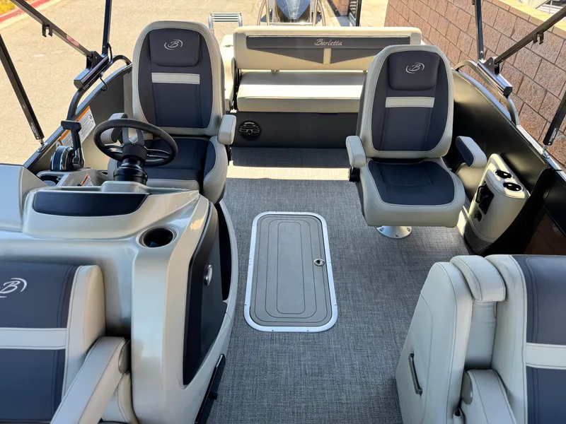 Slide: The Image of 2023 Barletta Cabrio 24UC pontoon boat interior with plush seating and modern helm. - 12