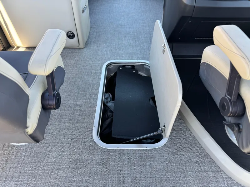 Slide: The Image of 2023 Barletta Cabrio 24UC boat interior storage compartment with open hatch and seating. - 23