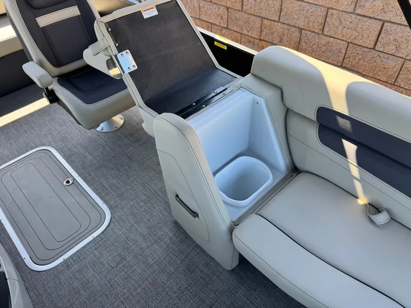 Slide: The Image of 2023 Barletta Cabrio 24UC boat interior with open storage compartment and seating. - 25