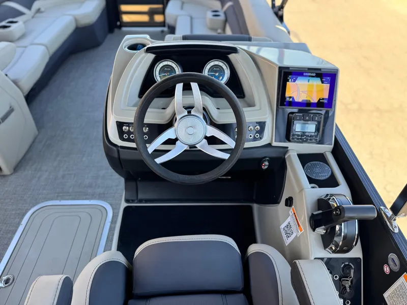 Slide: The Image of 2023 Barletta Cabrio 24UC boat dashboard with steering wheel and navigation display. - 28