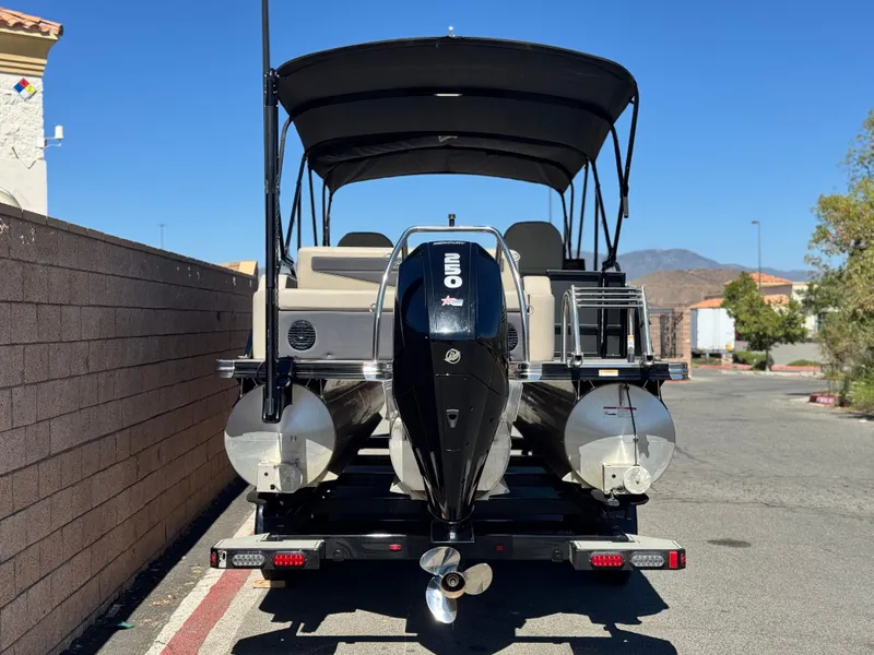 Slide: The Image of 2023 Barletta Cabrio 24UC pontoon boat with black canopy and outboard motor. - 5