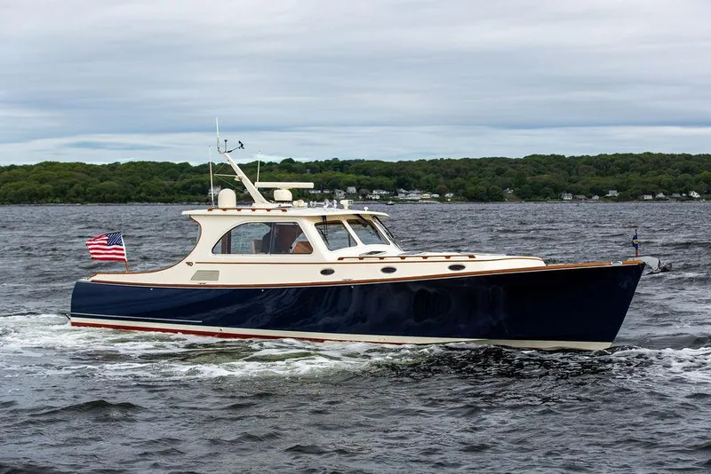 Slide: The Image of 2007 Hinckley Talaria 44 MY cruising on a lake with an American flag. - 1