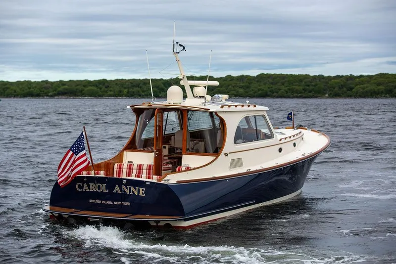 Slide: The Image of 2007 Hinckley Talaria 44 MY yacht cruising on open water, displaying American flag. - 14