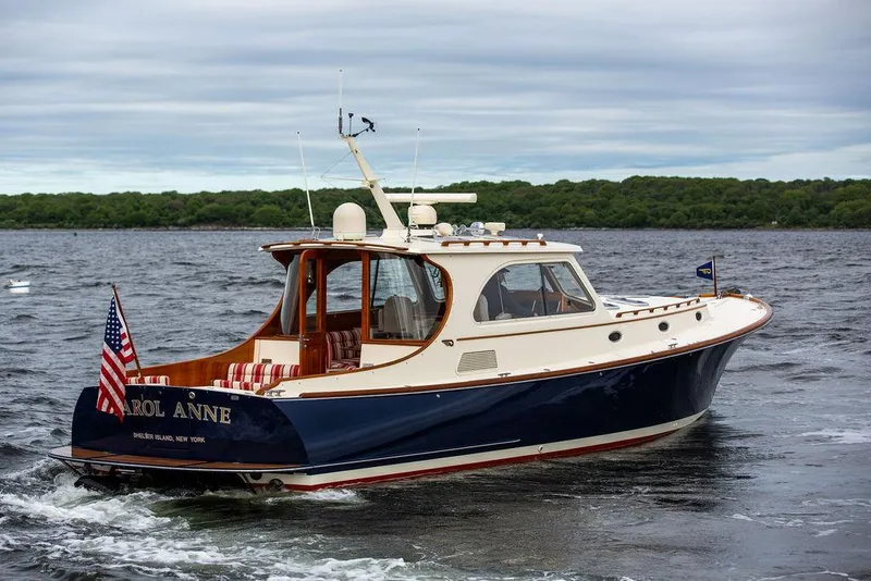 Slide: The Image of 2007 Hinckley Talaria 44 MY yacht cruising on a lake with lush green shoreline. - 15