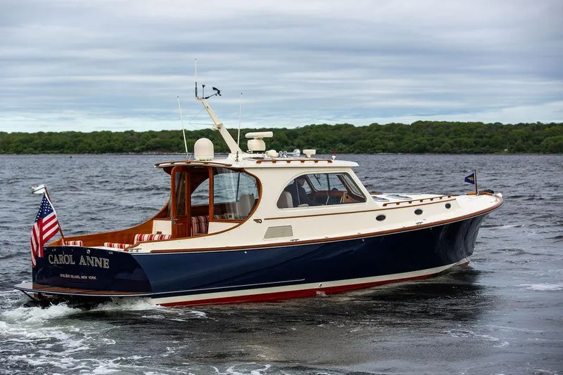 Slide: The Image of 2007 Hinckley Talaria 44 MY yacht cruising on a lake with lush green shoreline. - 16