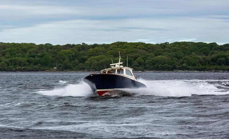 Slide: The Image of 2007 Hinckley Talaria 44 MY cruising on a scenic waterway with lush green shoreline. - 34