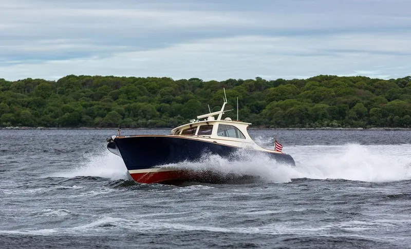 Slide: The Image of 2007 Hinckley Talaria 44 MY cruising on a choppy sea with lush green shoreline. - 35