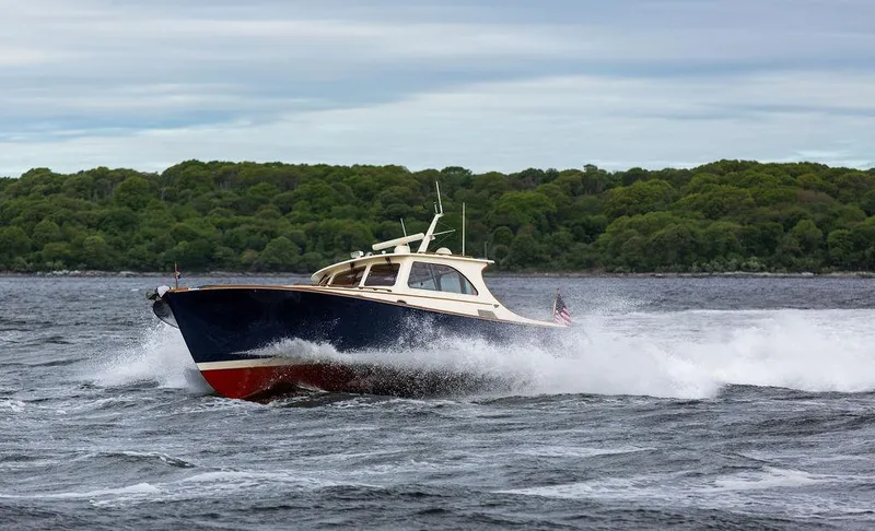 Slide: The Image of 2007 Hinckley Talaria 44 MY cruising on water with lush green shoreline in background. - 36