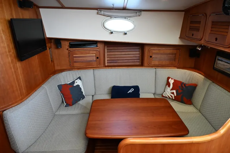 Slide: The Image of Cozy interior of 2007 Hinckley Talaria 44 MY yacht with cushioned seating and wooden table. - 45