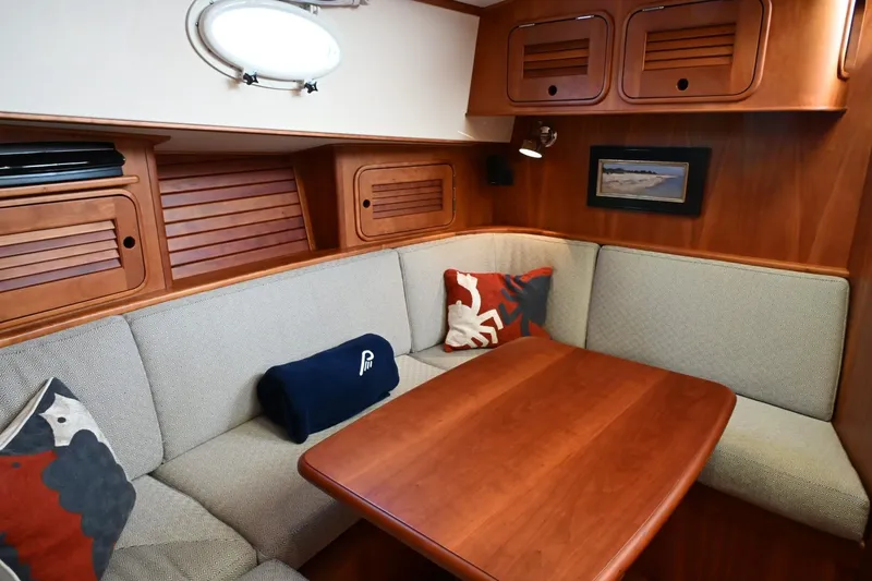 Slide: The Image of Cozy interior of 2007 Hinckley Talaria 44 MY with wooden table and cushioned seating. - 46