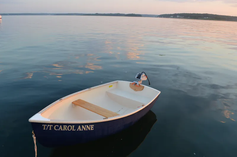 Slide: The Image of Small boat named "T/T Carol Anne" floating on calm water at sunset. - 47