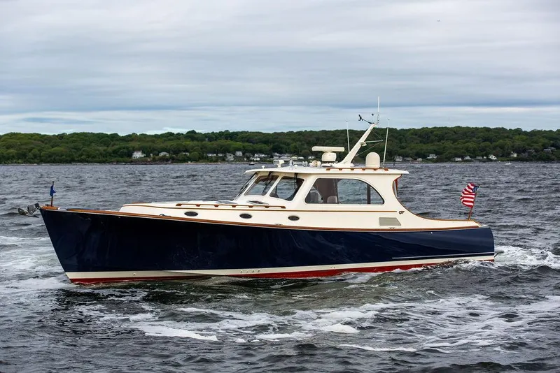 Slide: The Image of 2007 Hinckley Talaria 44 MY cruising on a lake with lush green shoreline. - 7