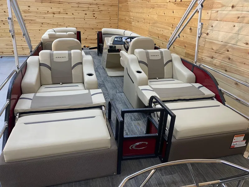 Slide: The Image of 2023 Crest Classic LX 220 SLRC pontoon boat interior with luxurious seating and wood paneling. - 10