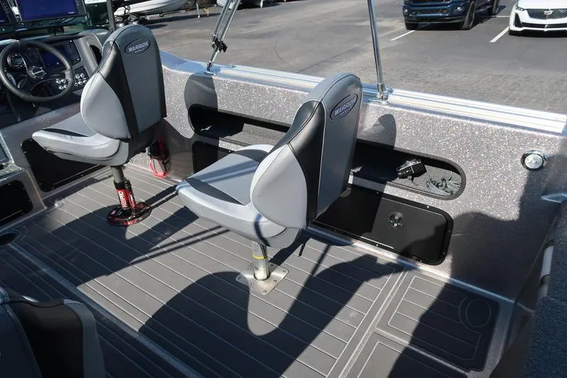 Slide: The Image of 2024 Warrior 238 DC boat interior with two swivel seats and a sleek dashboard. - 19