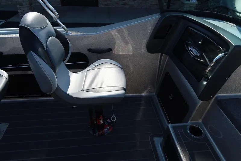 Slide: The Image of 2024 Warrior 238 DC boat interior with sleek seating and modern dashboard design. - 20