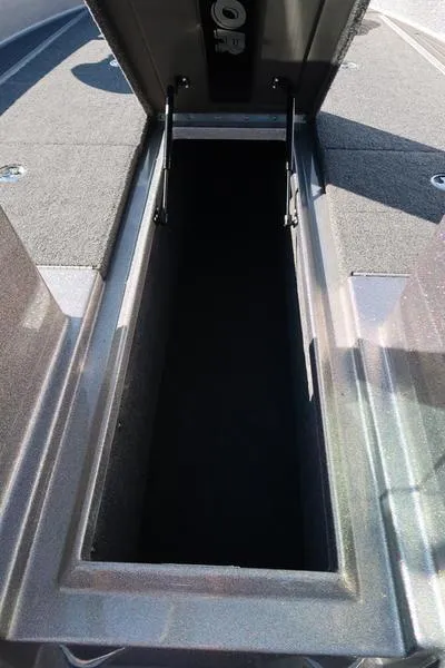 Slide: The Image of 2024 Warrior 238 DC boat storage compartment with open lid, showcasing spacious interior. - 29
