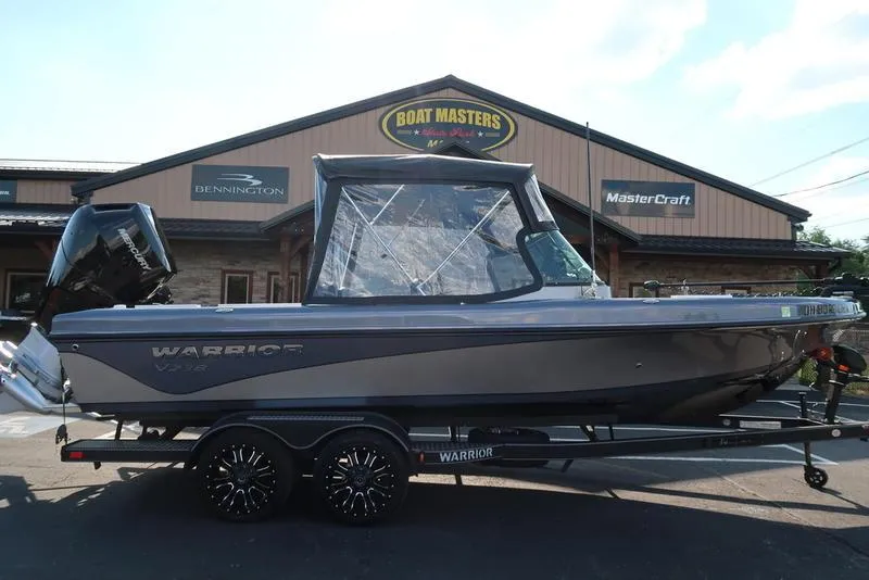 Slide: The Image of 2024 Warrior 238 DC boat on trailer outside dealership, featuring sleek design and modern features. - 3