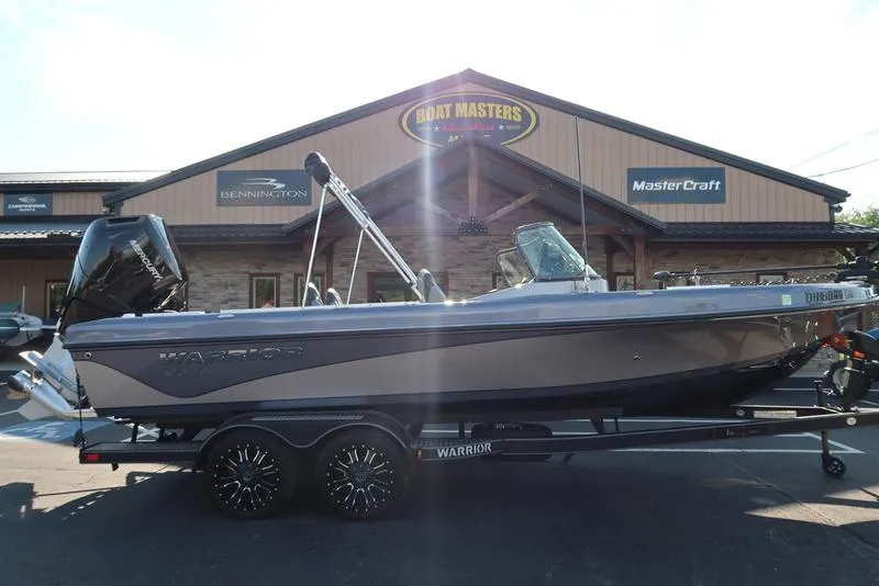 Slide: The Image of 2024 Warrior 238 DC boat on trailer outside dealership, featuring sleek design and modern features. - 5