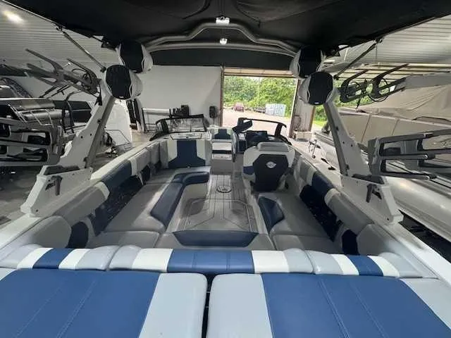 Slide: The Image of 2022 Malibu 21 LX boat interior with blue and white seating, in a showroom. - 4