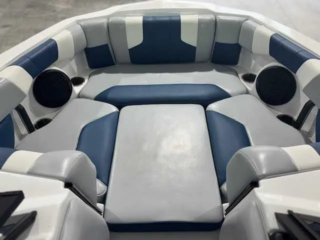 Slide: The Image of 2022 Malibu 21 LX boat interior with blue and white cushioned seating. - 5