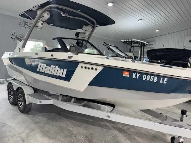 Slide: The Image of 2022 Malibu 21 LX boat on trailer in indoor showroom. - 9