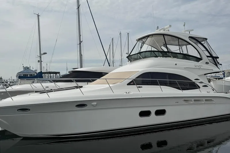 The Image of 2010 Sea Ray 520 Sedan Bridge yacht on calm water under clear blue sky. - 0