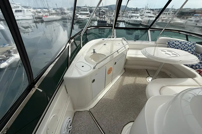 Slide: The Image of 2010 Sea Ray 520 Sedan Bridge interior with seating, table, and marina view. - 12