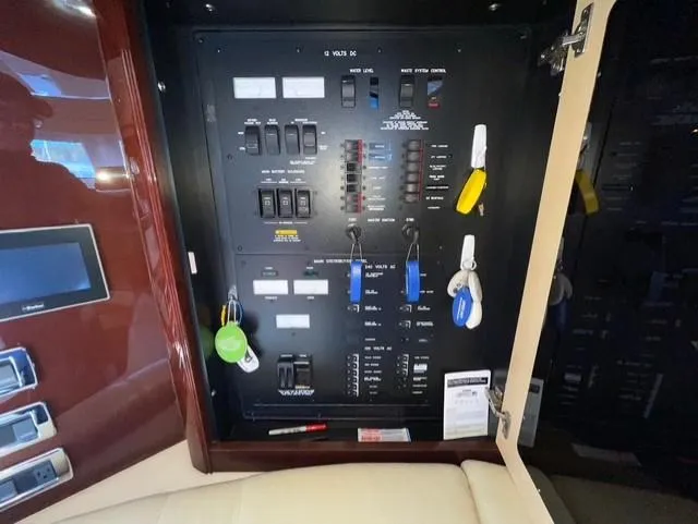 Slide: The Image of Electrical panel inside 2010 Sea Ray 520 Sedan Bridge yacht with labeled switches and key holders. - 18