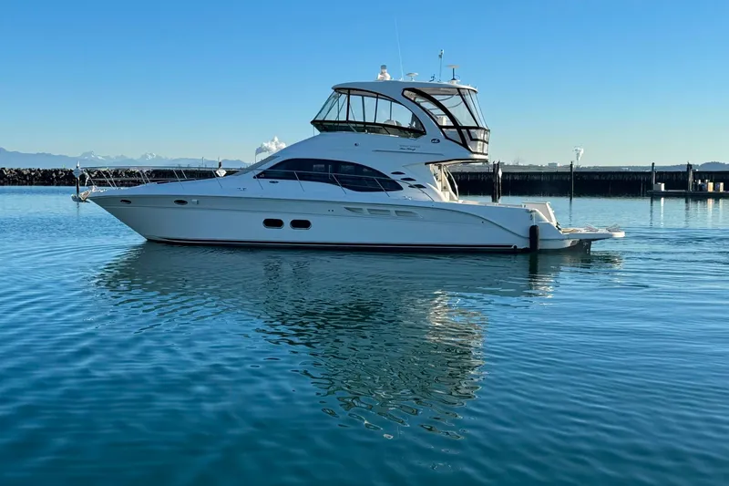 Slide: The Image of 2010 Sea Ray 520 Sedan Bridge yacht on calm water, clear sky background. - 25