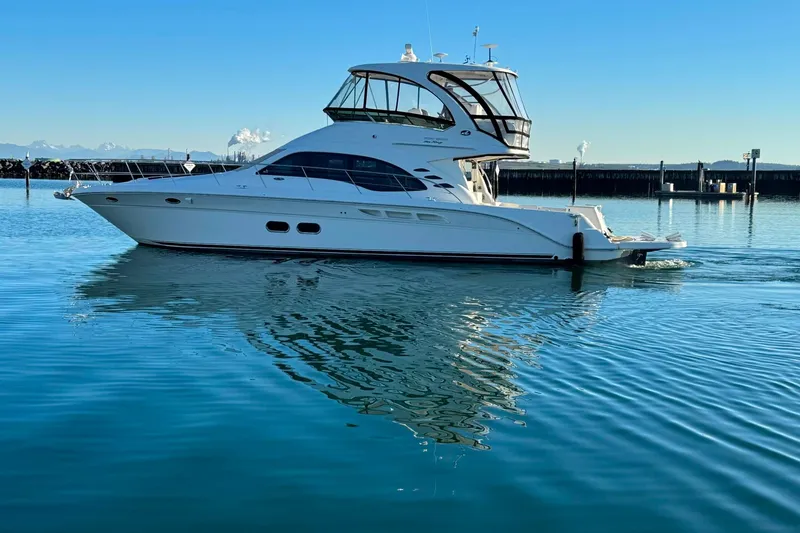 Slide: The Image of 2010 Sea Ray 520 Sedan Bridge yacht on calm water, clear sky background. - 26