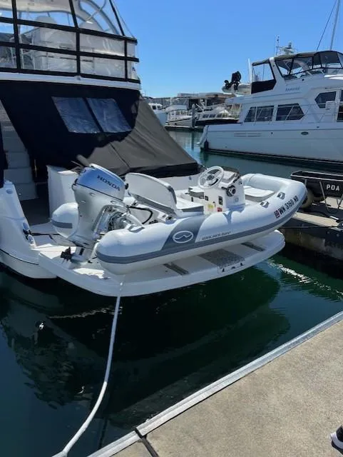 Slide: The Image of 2010 Sea Ray 520 Sedan Bridge with dinghy, docked at marina. - 3