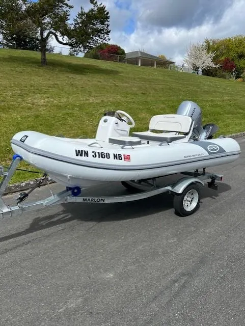 Slide: The Image of Small inflatable boat on trailer, parked on roadside with grassy background. - 5