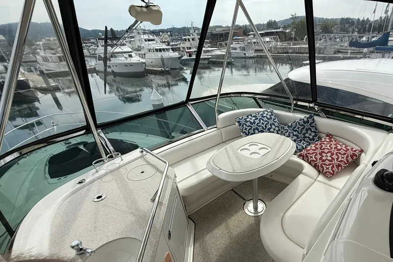 Slide: The Image of Luxurious 2010 Sea Ray 520 Sedan Bridge interior with marina view, featuring plush seating and cushions. - 7