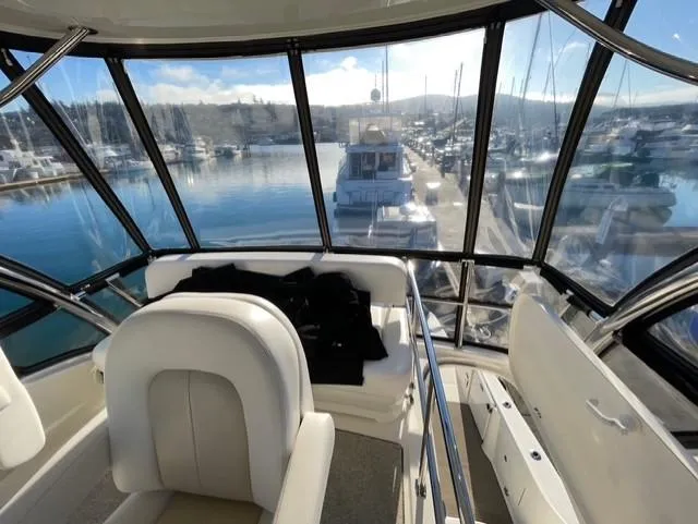 Slide: The Image of 2010 Sea Ray 520 Sedan Bridge interior with marina view through large windows. - 8