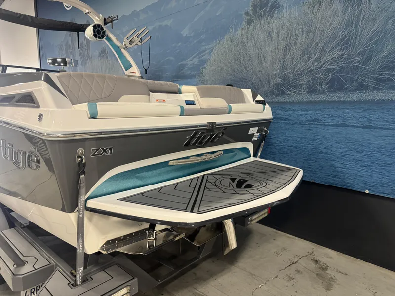 Slide: The Image of 2019 Tigé ZX1 boat with swim platform, displayed indoors against a scenic backdrop. - 4