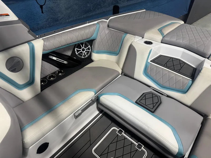 Slide: The Image of 2019 Tigé ZX1 boat interior with gray and blue quilted seating, cup holders, and speaker. - 7