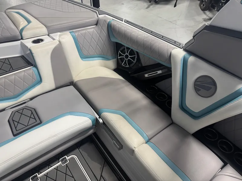 Slide: The Image of 2019 Tigé ZX1 boat interior with gray and blue cushioned seating and cup holders. - 9