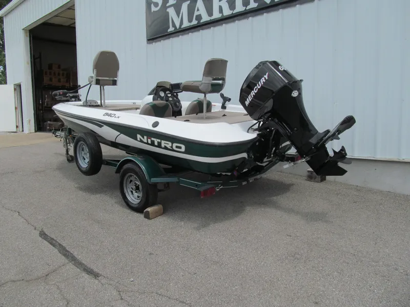 Slide: The Image of 2006 Nitro 640 LX boat with Mercury engine on trailer outside marine shop. - 2