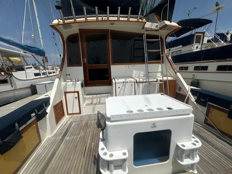 Slide: The Image of 1986 Egg Harbor SPORT FISHER boat deck with fishing equipment and wooden accents. - 23