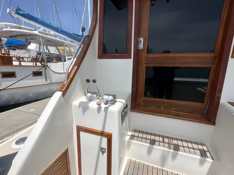 Slide: The Image of 1986 Egg Harbor SPORT FISHER boat controls and wooden door, docked near other vessels. - 26