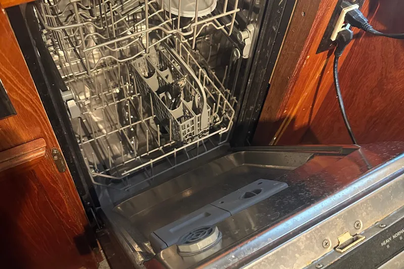 Slide: The Image of Open dishwasher inside 1986 Egg Harbor SPORT FISHER boat, showing racks and cutlery holder. - 4