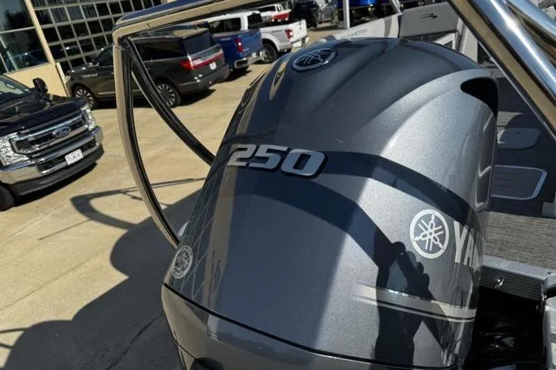 Slide: The Image of 2025 Bennington 25 SXSR with Yamaha 250 outboard engine in a dealership lot. - 18