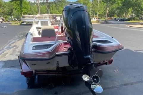 Slide: The Image of 2000 ProCraft 170 Combo boat with outboard motor, parked on a sunny day. - 2