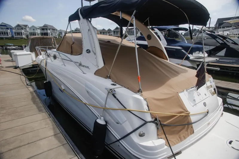 Slide: The Image of 2002 Sea Ray 300 Sundancer docked with protective cover, marina background. - 10